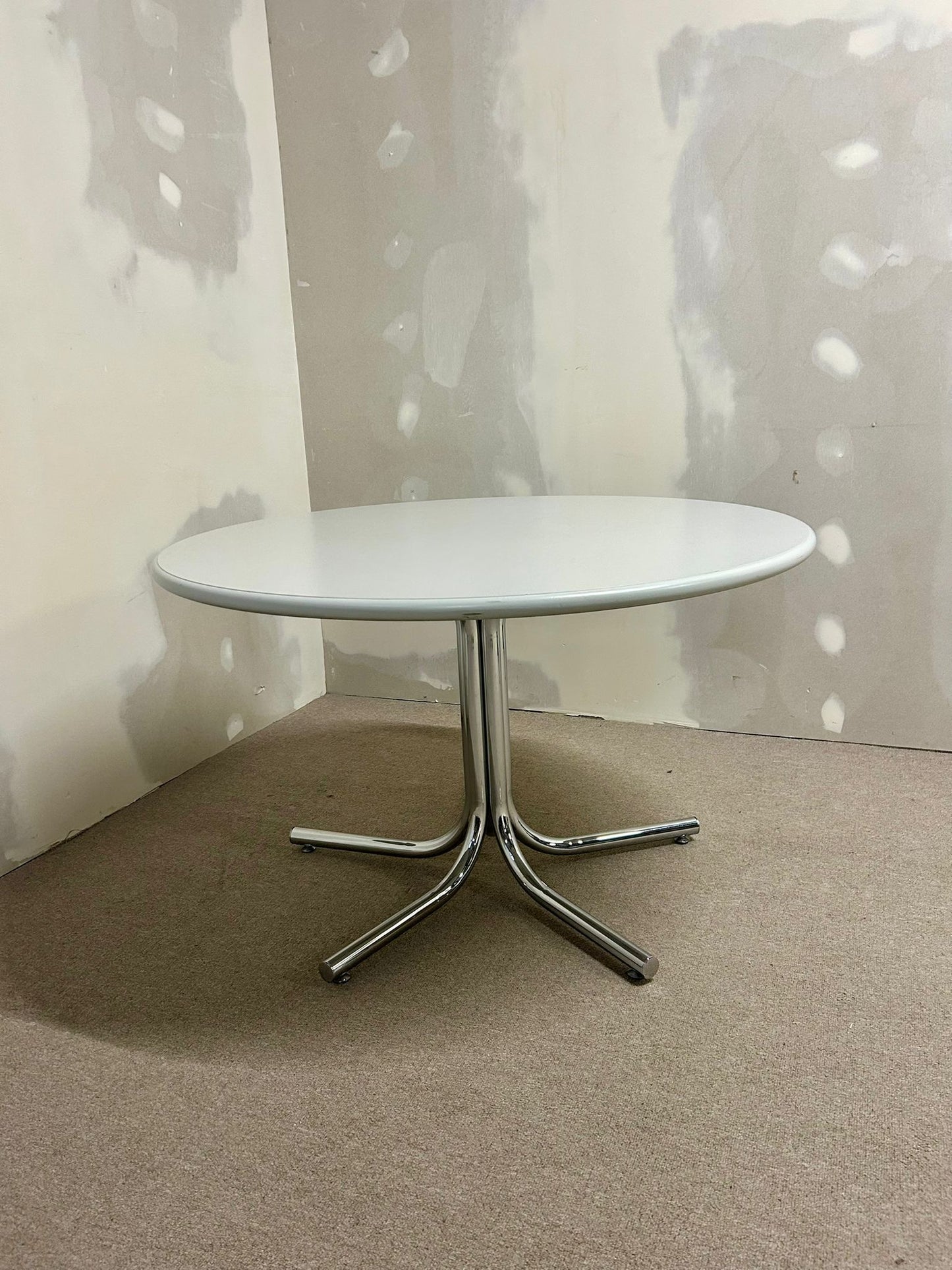 Runder Tisch mit Chrom-Füsse und grau-weisser Platte